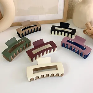 Macro shot of large square matte hair claws in various dual-tone colors and frosted finish