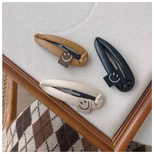 Detail of PU leather waterdrop hair clips with smiley labels in black brown and beige