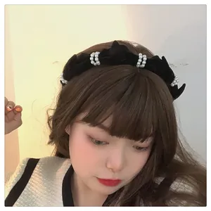 Close-up of a French vintage black velvet headband with elegant pearls on a model