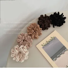 Set of five plush thick elastic scrunchies in neutral earth tones on a beige table