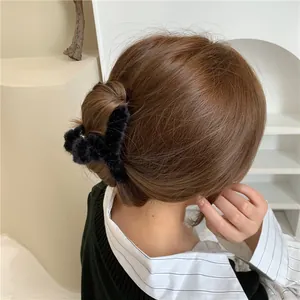 Detailed view of a black plush hair claw clip used for an elegant updo on long wavy hair