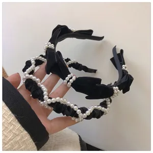Close-up of black velvet headbands featuring faux pearls and elegant ribbon bows