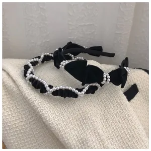 Close-up of vintage black velvet headbands with elegant white pearls and bow details