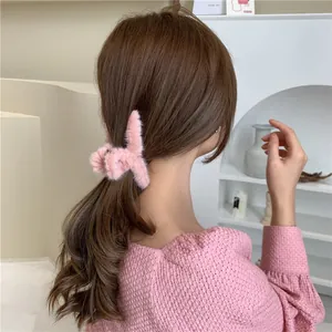 Detailed view of a soft pink plush rabbit hair claw clip worn on a woman's hair