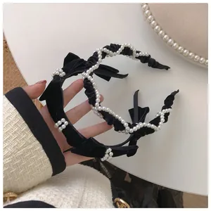 Detail of black velvet headbands featuring pearls and elegant bow knot ornaments