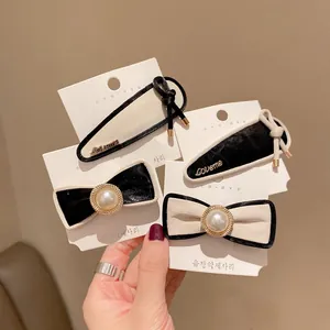 Elegant set of black and white sheepskin bow hair clips with pearls and Loveme metal lettering