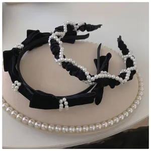 Detail of black velvet headbands featuring elegant pearl clusters and chic velvet bows