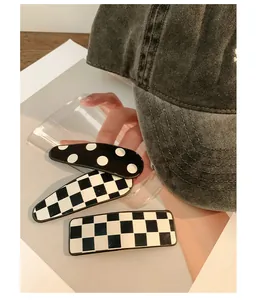Close-up of checkerboard and polka dot hair clips set on a stylish fashion accessory background
