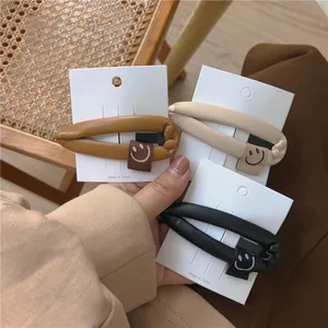 Three minimalist PU leather drop-shaped hair clips with cute smiley face embroidery patches