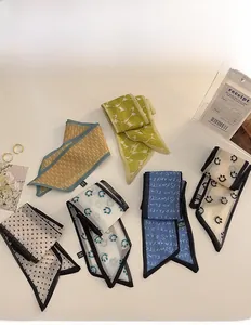 Close-up of assorted floral and polka dot satin scarves with elegant prints and silky texture