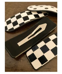 Close-up of checkered and polka dot snap hair clips on a natural wood surface