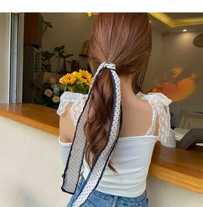 Polka dot chiffon hair scarf tied in a bow on a low ponytail for a sweet look