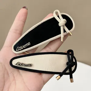 French retro style faux leather bow hair clip with gold Loveme metal emblem