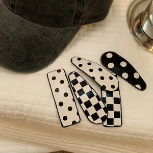 5-piece black and white checkerboard and polka dot hair clips set on white fabric