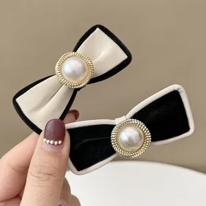 Detail of premium PU leather bow hair clips with faux pearls and gold metal gear settings
