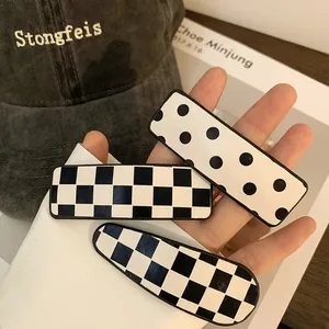 Three-piece hair clip set featuring black and white checkerboard and polka dot patterns
