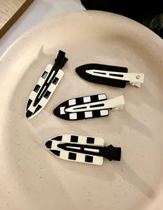 Detail view of 4-piece black and white checkered and striped no-bend hair clips