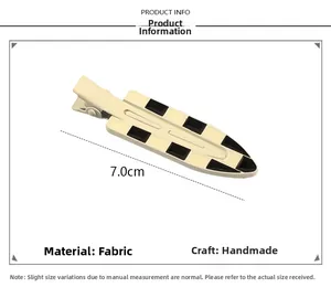 Macro detail of 7.0cm checkerboard fabric hair clip showing handmade craftsmanship