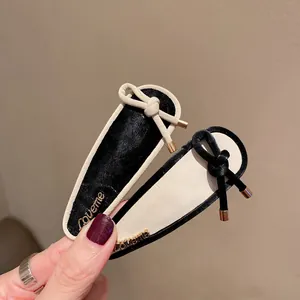 Chic faux leather bow hair clip set in black and cream with gold accents