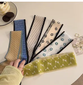 Detailed view of six patterned silk-like twilly scarves for hair and bag styling