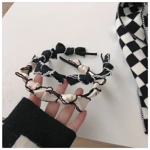 Detailed fabric texture of retro bow headbands in black and white contrast colors