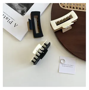 Macro shot of large rectangular matte shark hair claws in black and cream color block