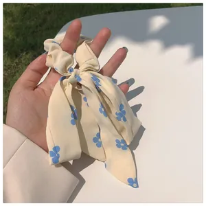 Detailansicht eines cremefarbenen Blumen-Haargummis mit langen Bändern und Blumenmuster