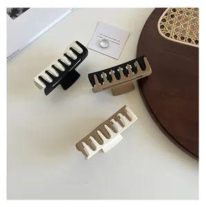 Three large matte square shark hair claws in classic color block combinations on a tray