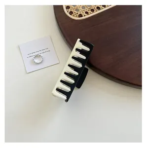 Large black and white contrast rectangle hair claw clip on an elegant tabletop