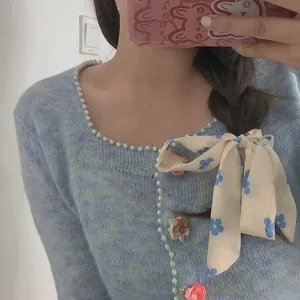 Hellblaue Strickjacke mit weißen Perlen, 3D-Blumenakzenten und einer großen Satinschleife