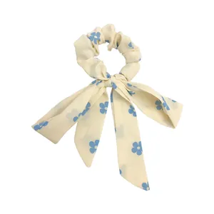 Eleganter cremefarbener Haargummi mit langen Bändern und feinen blauen Blumenmustern