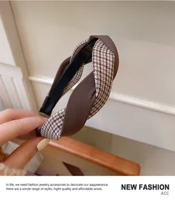 Detailed texture of brown houndstooth and ribbed fabric twist on a retro wide headband