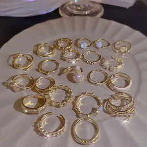 Elegantes Gold-Blumenring-Set mit Perlen und Zirkonia in einer Keramikschale