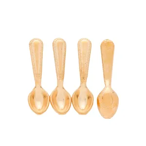 Detailed macro view of four mini gold vintage style spoons with beaded edge detailing
