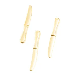 Macro detail of three golden miniature knife charms with textured metal handles