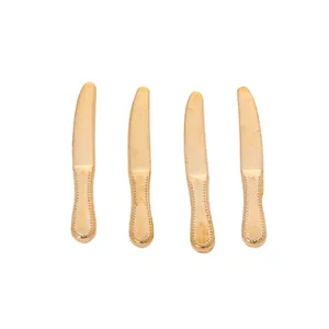 Detailed view of four vintage-style gold zinc alloy cutlery pendants for DIY jewelry