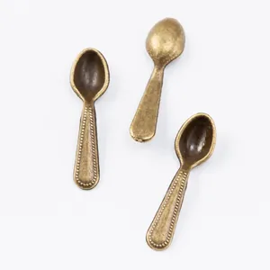Detailed macro view of 3 mini bronze alloy spoons measuring 19x5x3mm with embossed texture