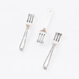 Close-up of three miniature vintage zinc alloy forks for DIY jewelry and crafts