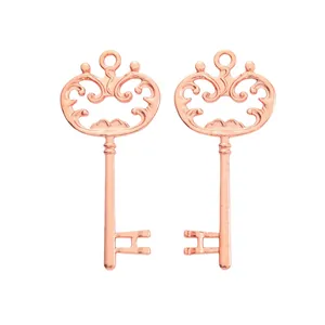 Pendentifs clés vintage en alliage or rose avec décorations ajourées sur fond blanc