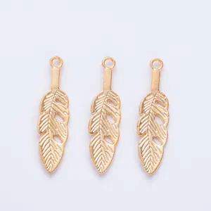 Detailed view of three vintage gold feather charms with intricate leaf vein textures