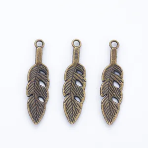 Three vintage bronze feather charms for DIY jewelry making with detailed leaf textures