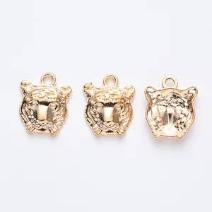 Gros plan détaillé de pendentifs têtes de tigre dorées vintage pour la création de bijoux