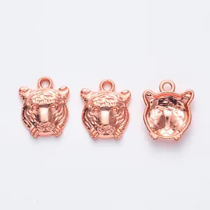 Détail des breloques tête de tigre en or rose montrant les textures avant et arrière creuses