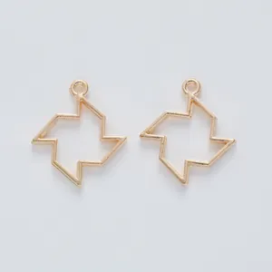 Detailed close-up of light gold geometric windmill charms for DIY jewelry making