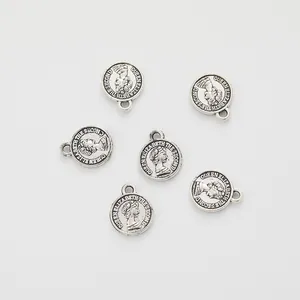 Macro shot of 6 antique silver round coin charms with Queen Elizabeth embossed relief
