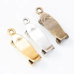 Tre ciondoli a forma di skateboard in lega di zinco nei colori oro, argento e bronzo