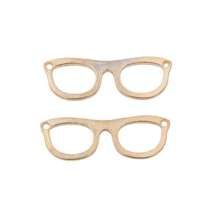 Close-up of golden spectacle frame pendants with polished finish and dual holes for jewelry DIY