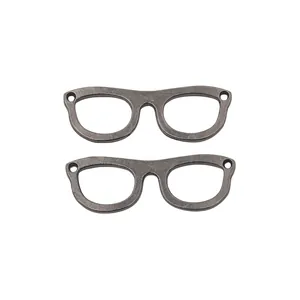 Close-up of vintage eyewear-shaped metal pendants with dual holes for DIY crafting