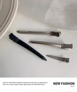 Macro view of black and silver metal hair clips set for professional styling and volume