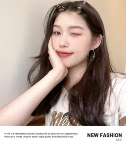Close-up of a model wearing irregular silver hoop earrings and hair clips
